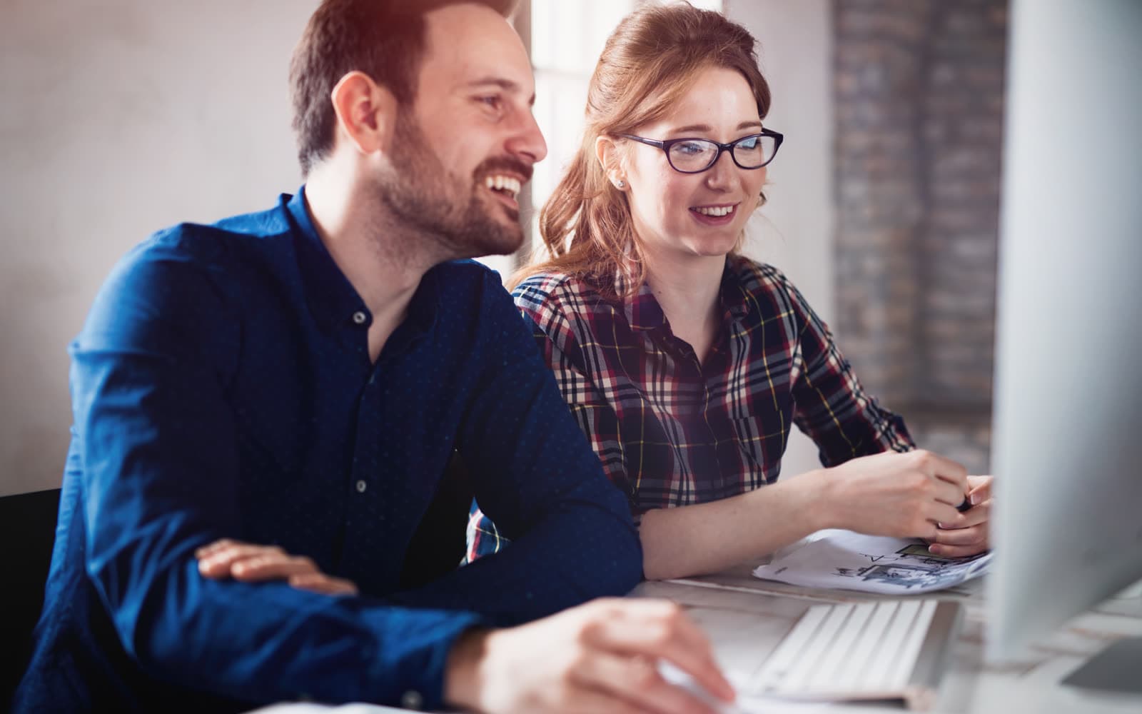 Two coworkers reviewing analytics together at a desk, representing the SEO Audit service offered through Whitehot Studio.